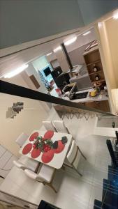 a kitchen with a white table and white chairs at Hospedagem Caripi in Barcarena