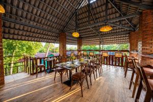 a dining room with a table and chairs on a deck at Solivo Ecolodge Phu Quoc in Phú Quốc +99 photos