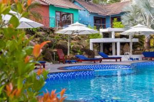 a swimming pool with chairs and umbrellas next to a house at Solivo Ecolodge Phu Quoc in Phú Quốc