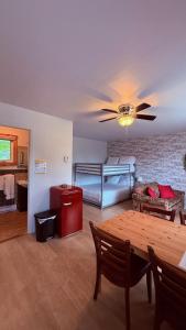 a living room with a table and a bunk bed at Les Petits Studios du bord de l'eau in Saint-Joseph-de-la-Rive