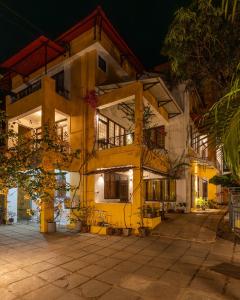 a large yellow building at night at Encontro Homestays in Dona Paula