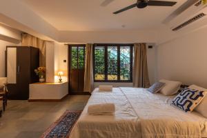 a large bed in a room with a large window at Encontro Homestays in Dona Paula
