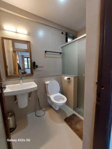 a bathroom with a white toilet and a sink at Encontro Homestays in Dona Paula +29 photos