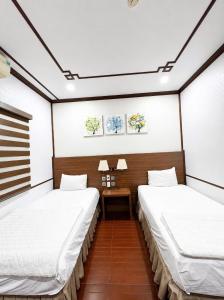a room with two beds and a table in it at Khách Sạn Phú Hưng 2 in Hanoi +18 photos