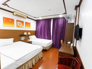 a hotel room with two beds and a television at Khách Sạn Phú Hưng 2 in Hanoi