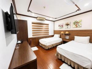 a hotel room with two beds and a television at Khách Sạn Phú Hưng 2 in Hanoi
