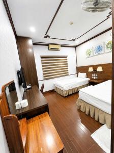 a room with two beds and a desk in a boat at Khách Sạn Phú Hưng 2 in Hanoi