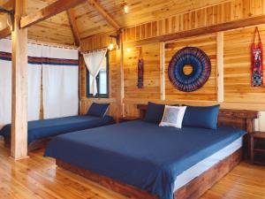 a bedroom with a bed in a log cabin at Ap Retreat - Ta Van's Heel in Sapa