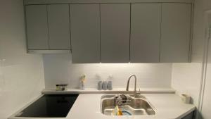 a kitchen with a sink and white cabinets at YuYu stay in Seoul +17 photos
