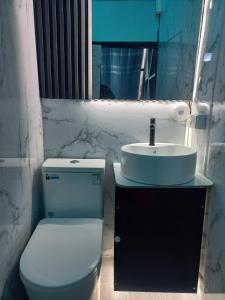 a bathroom with a white toilet and a sink at Glamping La Escapadita in Baños