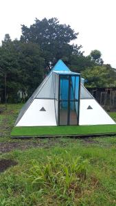 a tent with a door in a field of grass at Glamping La Escapadita in Baños