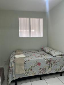 a bed in a white room with a window at Casa Mobiliada in Caruaru