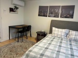 a bedroom with a bed and a table and a desk at Cozy Escape in the City in Port Coquitlam