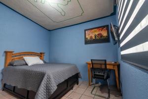 a bedroom with a bed and a table and a chair at Cómoda Casa a 7 minutos de la playa in Ciudad Madero
