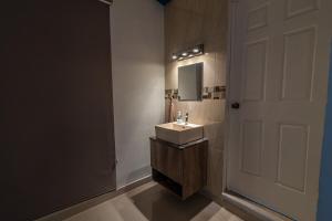 a bathroom with a sink and a mirror and a door at Cómoda Casa a 7 minutos de la playa in Ciudad Madero +23 photos