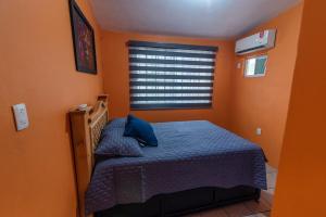 a bedroom with a bed with blue sheets and a window at Cómoda Casa a 7 minutos de la playa in Ciudad Madero