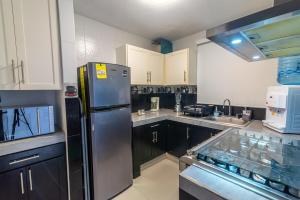 a kitchen with a stainless steel refrigerator and cabinets at Cómoda Casa a 7 minutos de la playa in Ciudad Madero