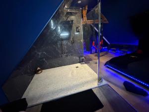 a room with a glass shower with a blue light at Maison love rooms in Tours