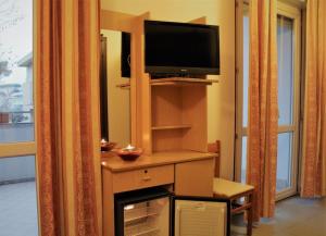 a living room with a television and a fireplace at Hotel Midi in Riccione