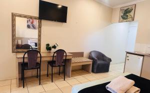 a room with a desk and two chairs and a mirror at Charters Towers Motel in Charters Towers