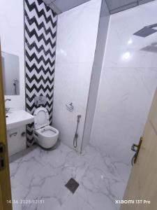 a white bathroom with a toilet and a sink at فندق سيوار in Erbil +15 photos