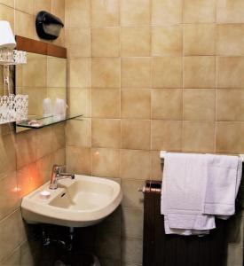 a bathroom with a sink and white towels at Hotel Midi in Riccione