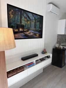 a living room with a flat screen tv on the wall at Sunset Ridge - King Bed Cabin & Breakfast Basket in Boyland