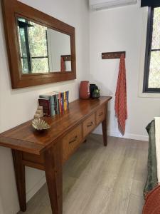 a wooden desk with a mirror and books on it at Sunset Ridge - King Bed Cabin & Breakfast Basket in Boyland