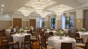 ein Festsaal mit weißen Tischen und Stühlen und Kronleuchtern in der Unterkunft Hotel Longmont in Longmont