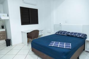 a bedroom with a bed with a desk and a window at Loft Completo com Smart TV e Frigobar Compacto 08 in Presidente Prudente
