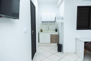 a kitchen with white cabinets and a white tile floor at Loft Completo com Smart TV e Frigobar Compacto 08 in Presidente Prudente +17 photos