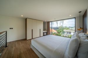 a bedroom with a large white bed and a large window at Horizon Apartment with Ocean View in Cemagi