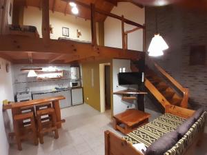 a kitchen and a living room with a loft at Cabañas LaMaria in Coronel Suárez