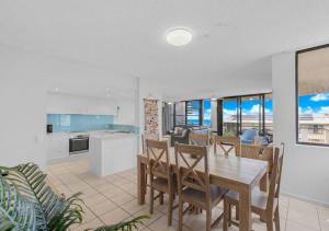 a kitchen and dining room with a table and chairs at Beach Days, Ocean Rooftop & Spa - Sleeps 8 in Marcoola