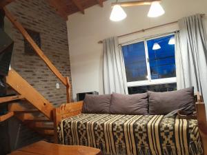 a living room with a couch and a window at Cabañas LaMaria in Coronel Suárez