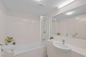 a white bathroom with a sink and a shower at Beach Days, Ocean Rooftop & Spa - Sleeps 8 in Marcoola +9 photos