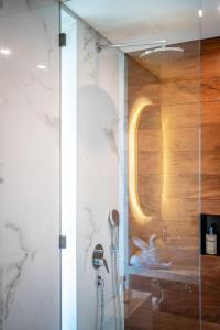 a shower with a glass door in a bathroom at Horizon Apartment with Ocean View in Cemagi +45 photos