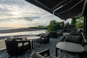 a restaurant with tables and chairs on the beach at Horizon Apartment with Ocean View in Cemagi