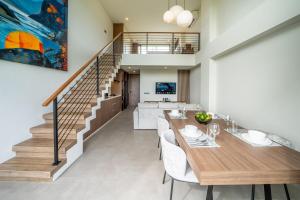 a dining room with a table and a staircase at Horizon Apartment with Ocean View in Cemagi