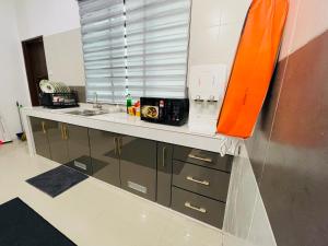 a kitchen with a sink and a counter top at D Azlin Homestay in Kuala Kangsar