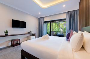 a bedroom with a large bed with a large window at The Sears Residence Siem Reap in Phumĭ Réach Born (2)