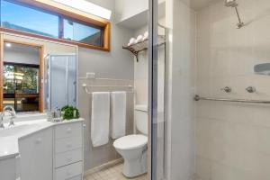 a bathroom with a toilet and a sink and a shower at Glassy Waters in Sussex Inlet +14 photos