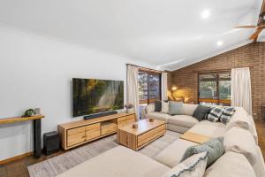 a living room with a couch and a tv at Glassy Waters in Sussex Inlet
