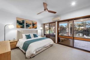 a bedroom with a bed and a ceiling fan at Glassy Waters in Sussex Inlet