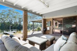 a living room with a couch and a table at Glassy Waters in Sussex Inlet