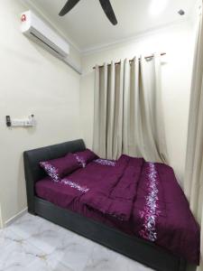a purple bed in a room with a window at Asyhani Cottage in Bachok