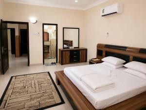 a bedroom with a large bed with white sheets at Al Shorooq Residential Complex مجمع الشروق السكني in Salalah