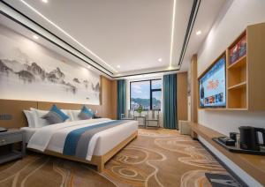 a bedroom with a large bed and a tv at Shenzhoujie International Hotel-3min to Forest Park East Gate&Tickets reserve-Personal Itinerary service- Shuttle service in Zhangjiajie +65 photos