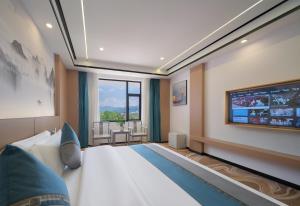 a bedroom with a large bed and a flat screen tv at Shenzhoujie International Hotel-3min to Forest Park East Gate&Tickets reserve-Personal Itinerary service- Shuttle service in Zhangjiajie