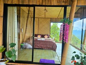 a bedroom with a bed and a large window at Mon Ngo misty haven B3 in Ban Nong Chaeng